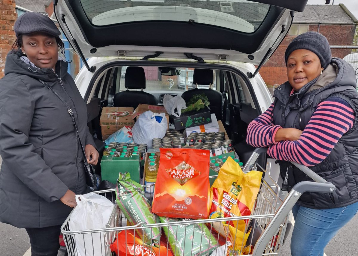 two women with shopping trolley and car full of food