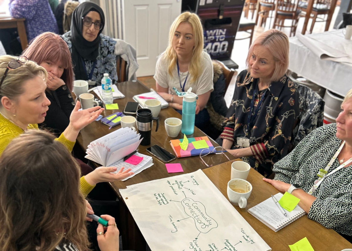 group women around table talking and making notes