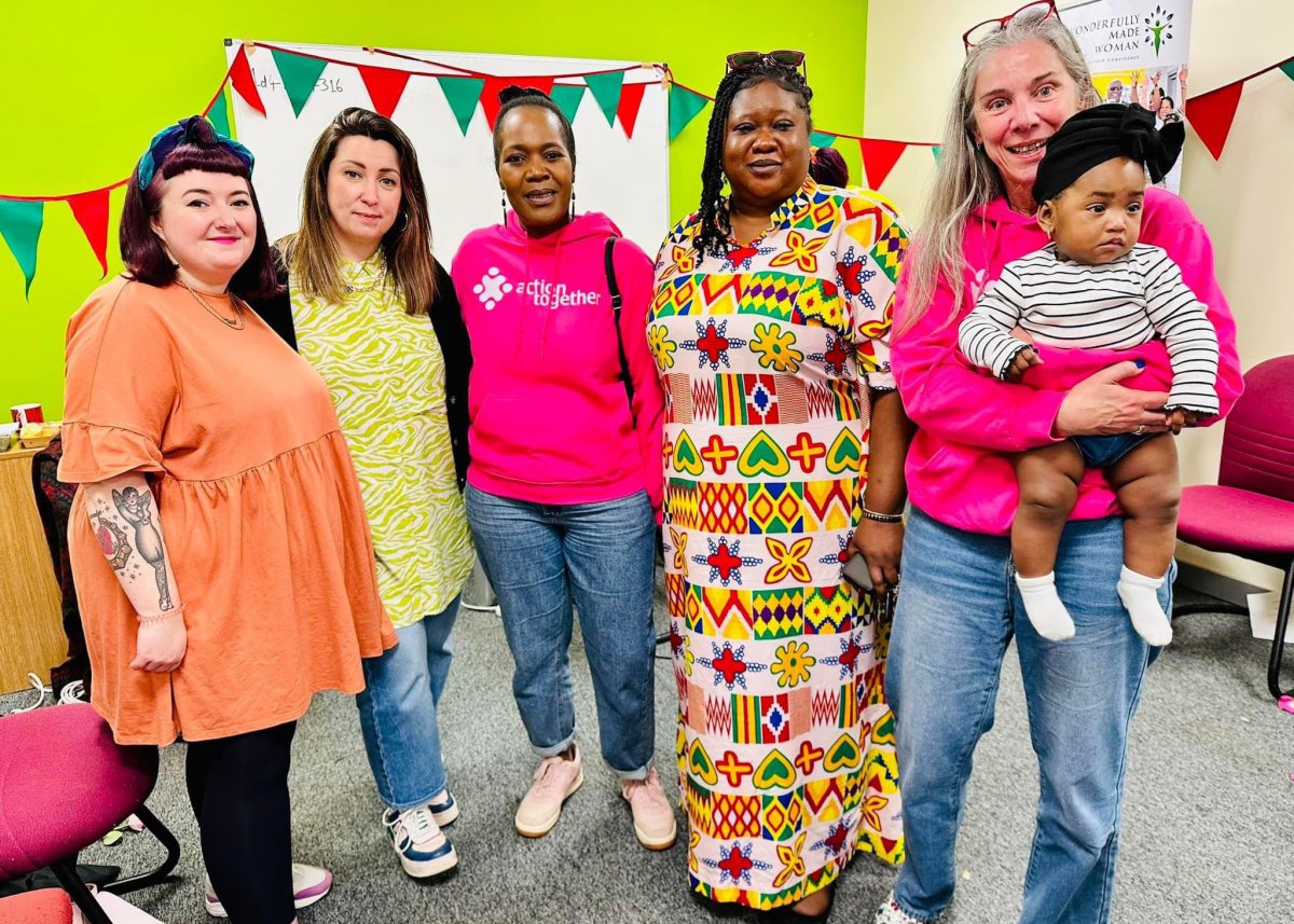 group of smiling women bright coloured clothes at community event