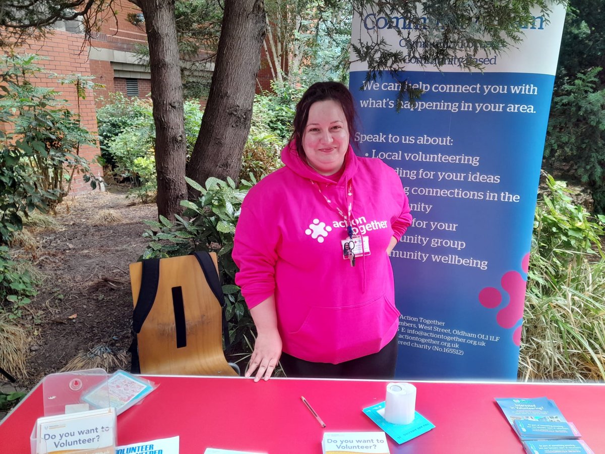 Person smiling at an information stall about volunteering