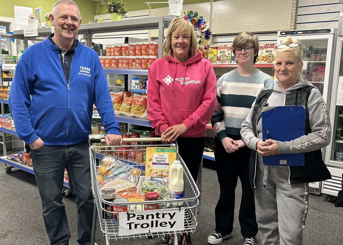 group of people with shopping trolley in food bank