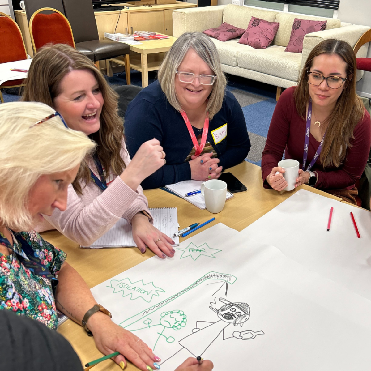 group of women chatting and smiling around a table