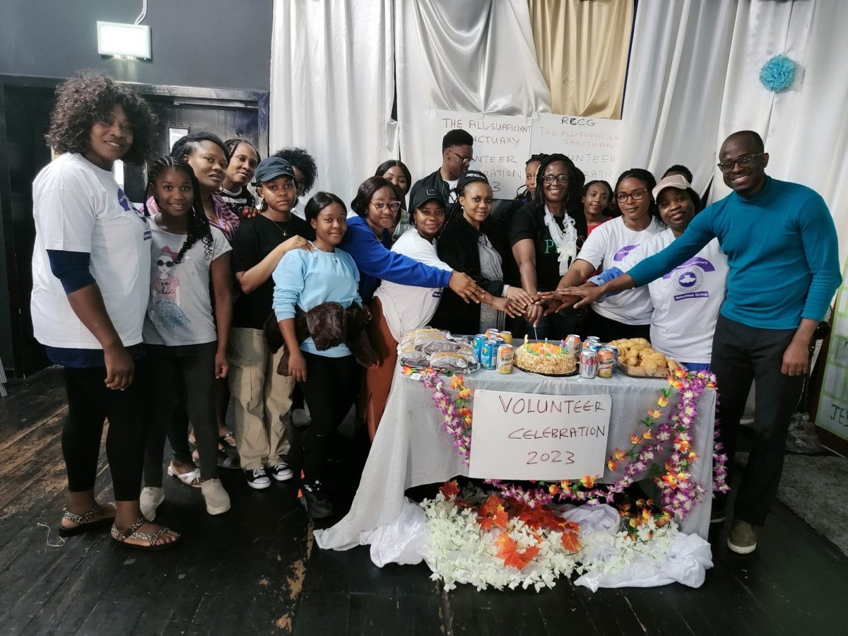 large group of people cutting cake at a celebration event