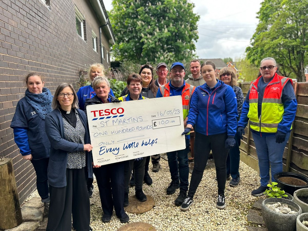 group of people holding large donation cheque