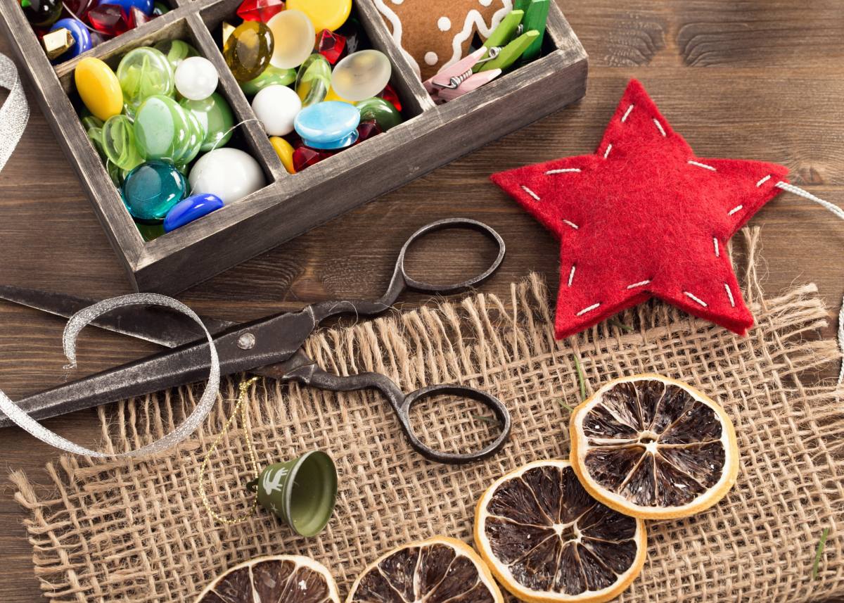 photo of craft equipment on wooden surface including scissors, beads etc