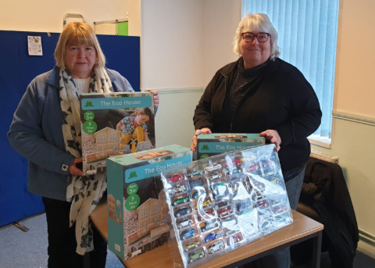 two women holding gifts of toy donations