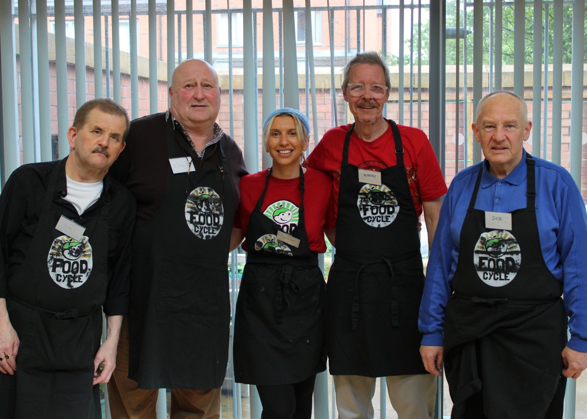 group of people wearing black aprons