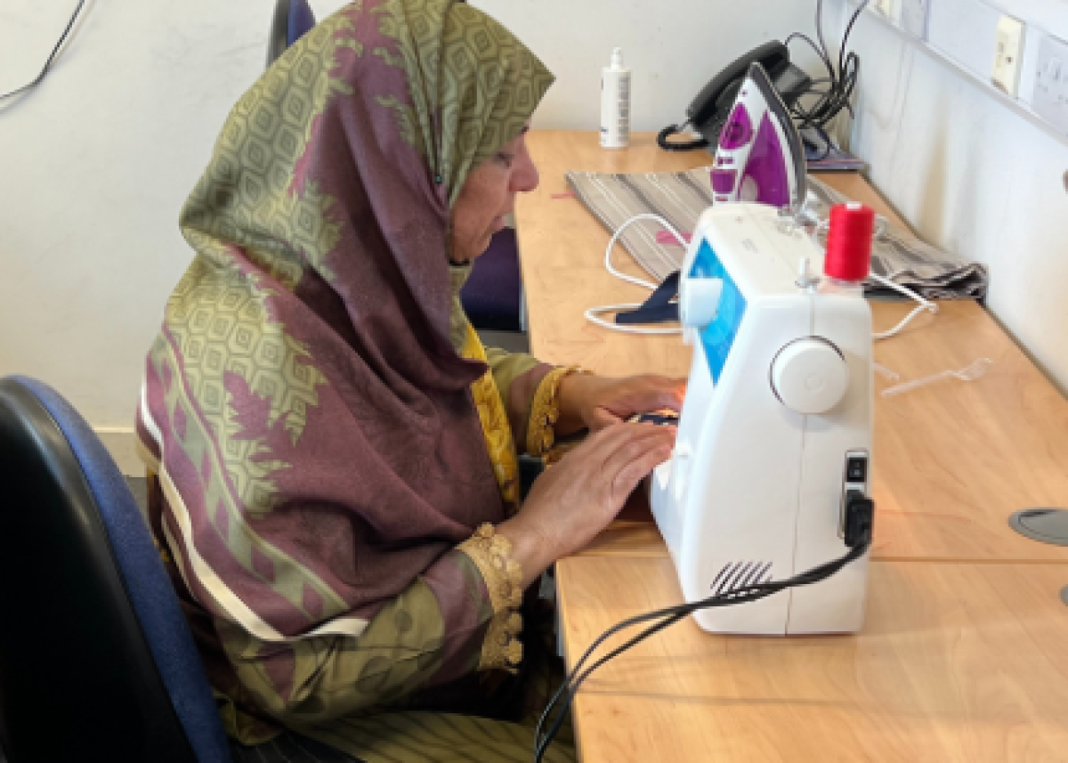 woman wearing head scarf using sewing machine