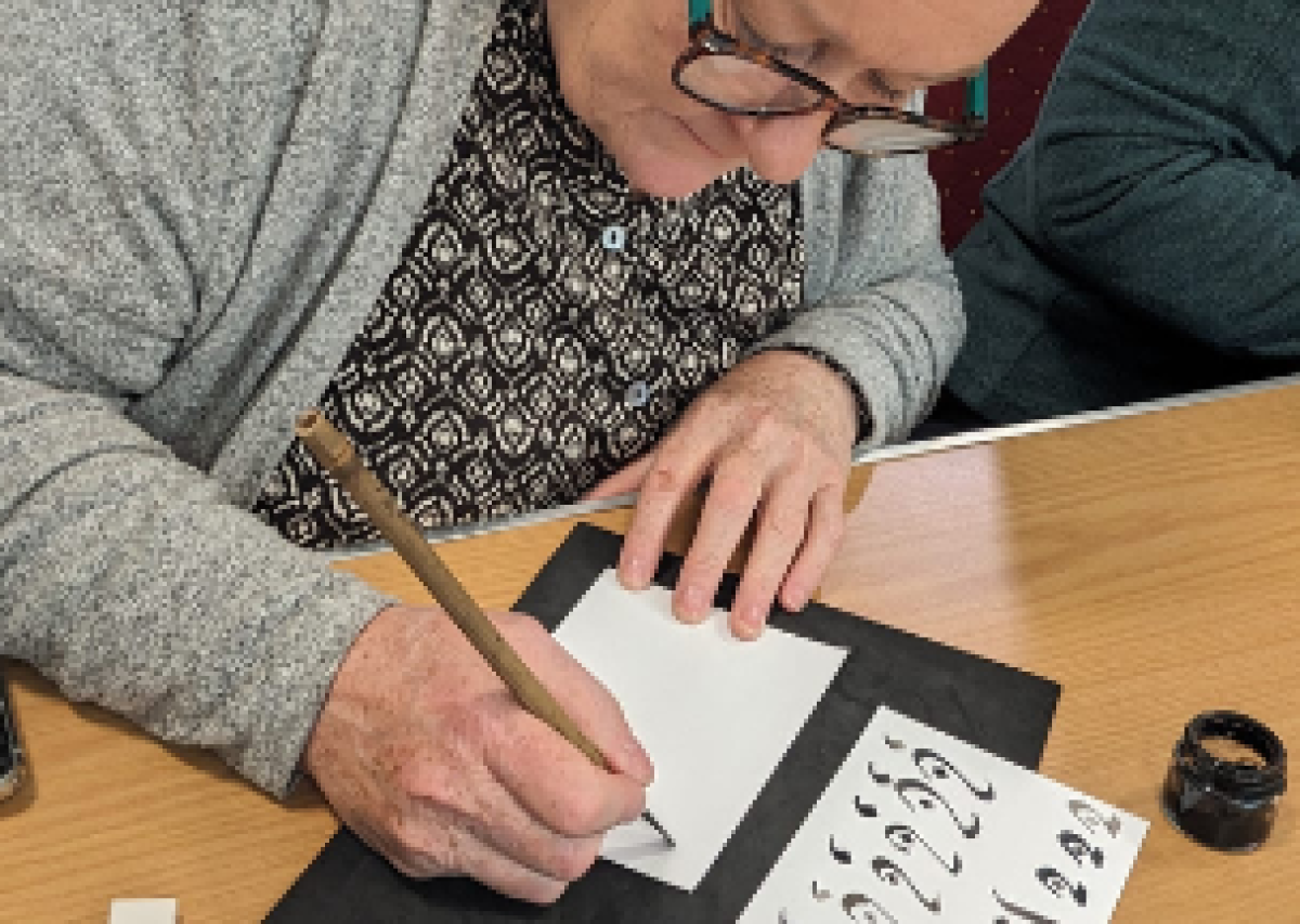 woman at desk doing calligraphic writing