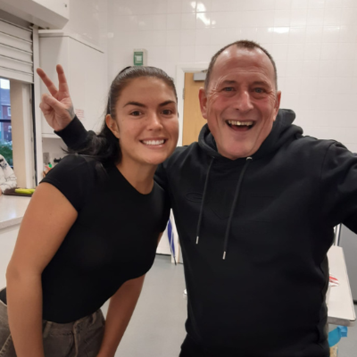 young woman and man weearing black t-shirts smiling at camera