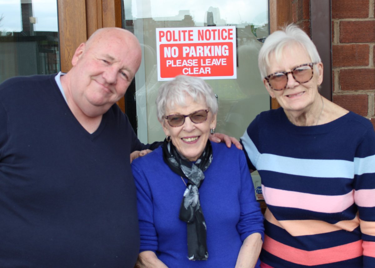 man and two women smiling at camera