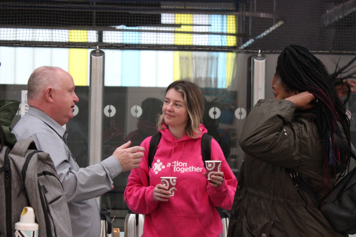 Action Together staff member listening to two people talking