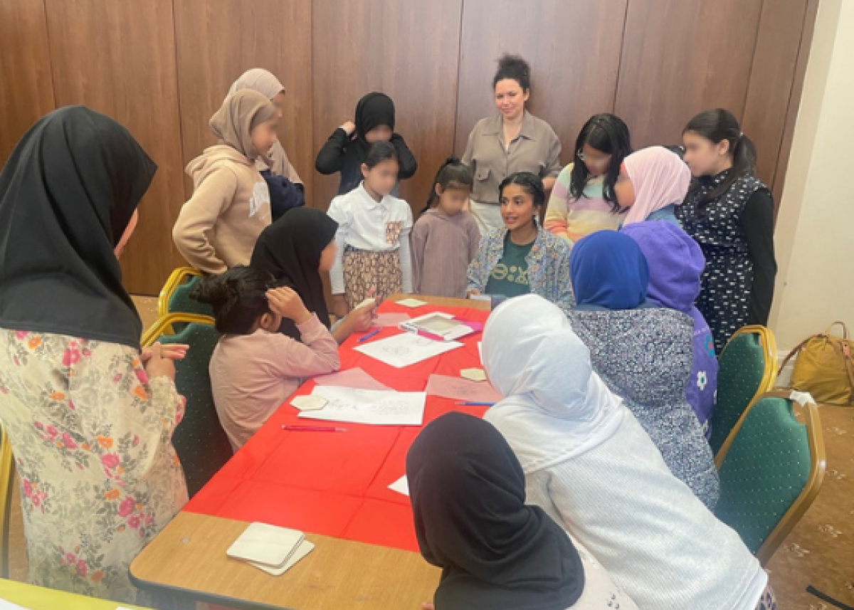 group of women and girls gathered round a table