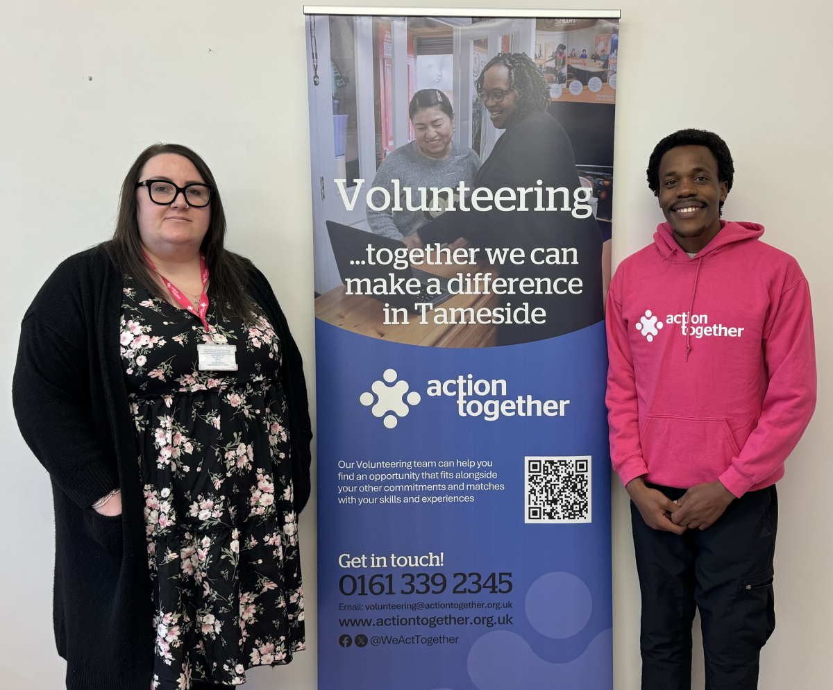 Photo of two staff with volunteering banner