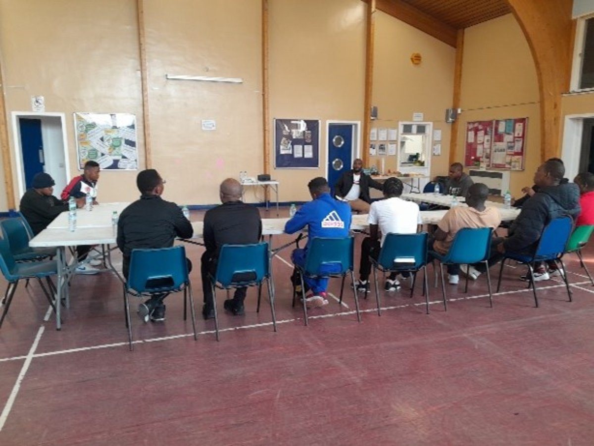 Group of men at community meeting around table