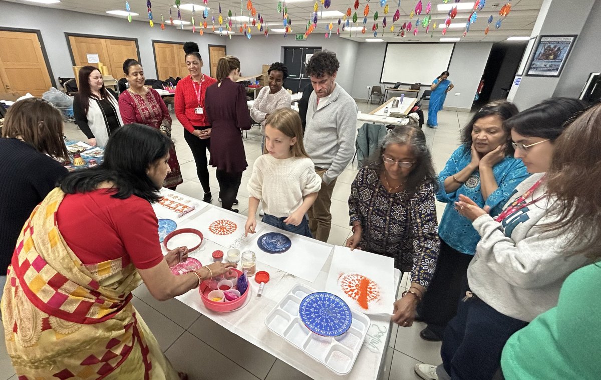 group of people crafting rangoli patterns