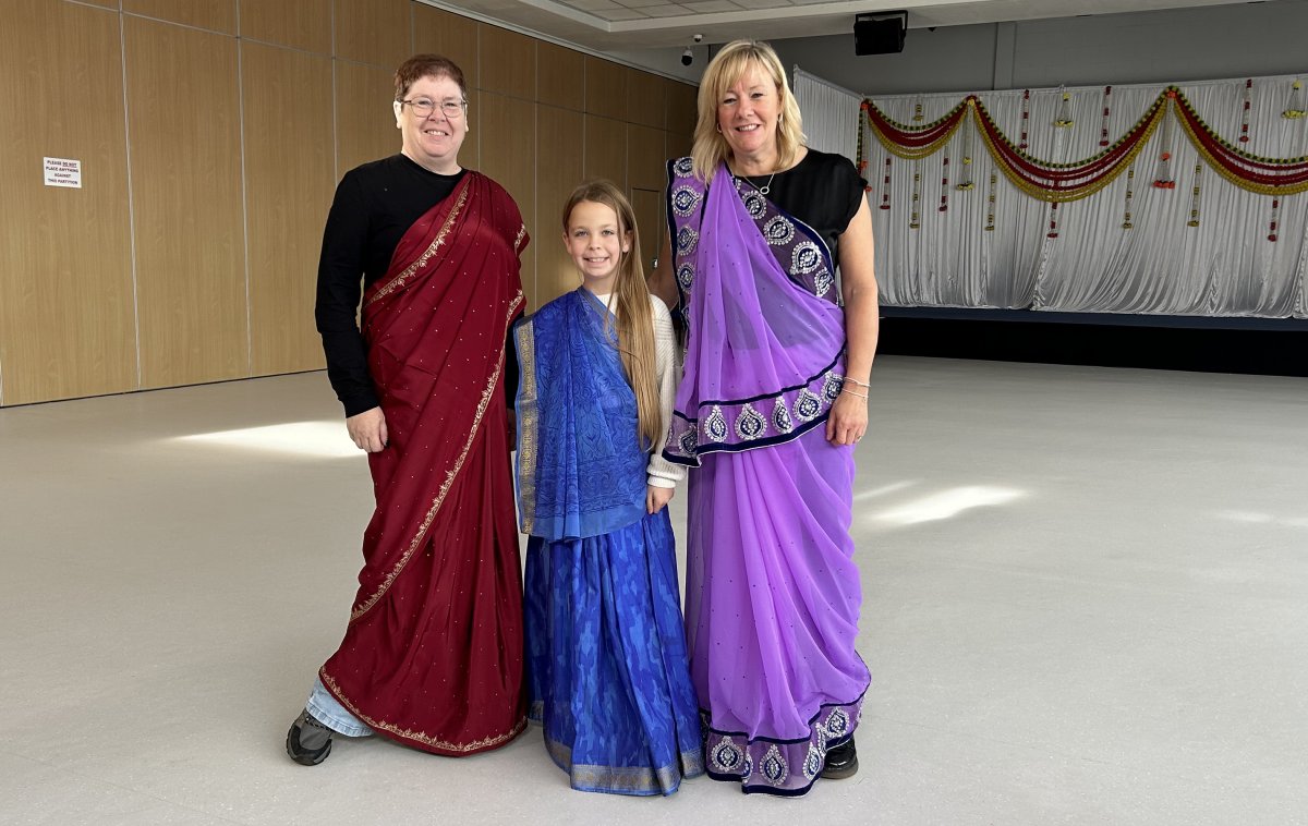 two ladies and a child dressed in saris