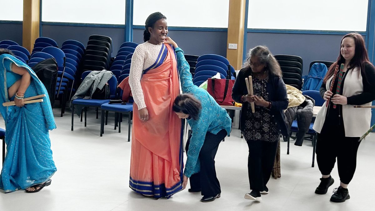 lady being dressed in traditional sari