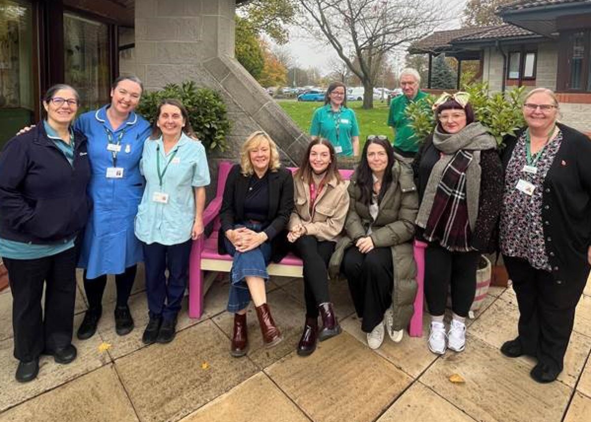 group of people sat around a bench at Springhill Hospice, Rochdale