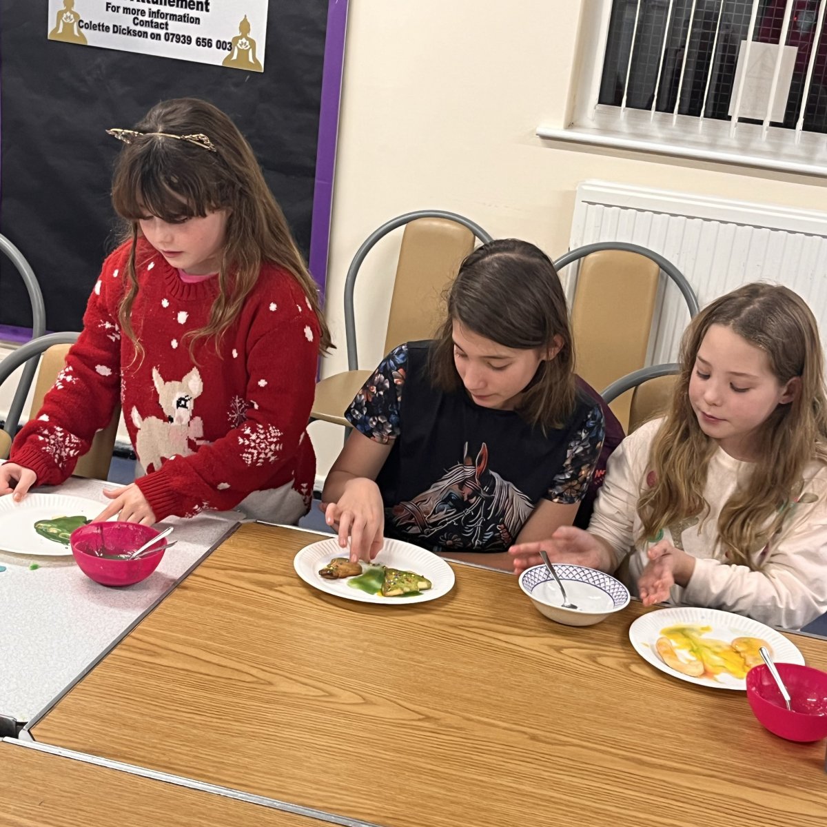 three girls decorating cookies at Girls Friendly Society